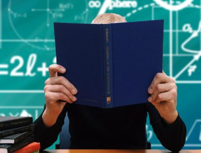 A Person Studying With A Book Hiding His Face.