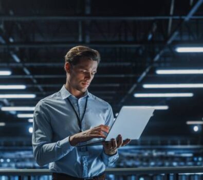 Portrait of a young male IT Specialist using Laptop in a Data Center.